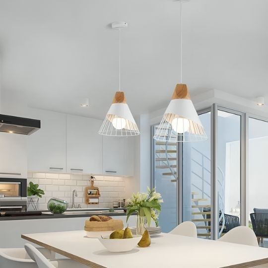   Deux suspensions luminaires blanches éclairent une table dans une cuisine moderne.